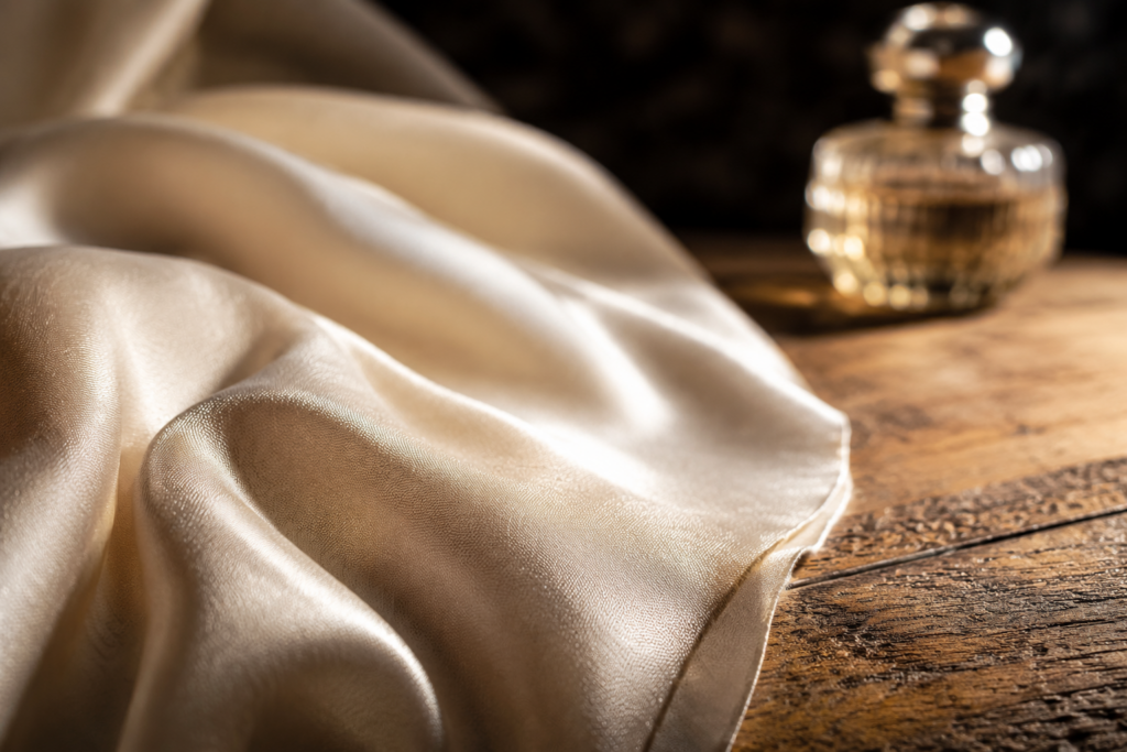 Sensorial Branding: dettaglio macro di seta drappeggiata e profumo, neuroscienza del lusso applicata